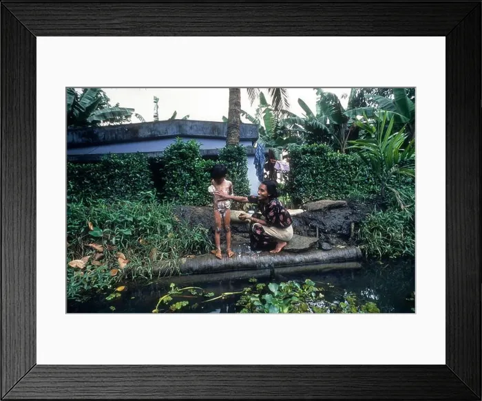 Framed Print : A Woman Bathing her daughter, Backwaters of kerala. Mother & child Framed Print : A Woman Bathing her daughter, Backwaters of kerala. Mother & child