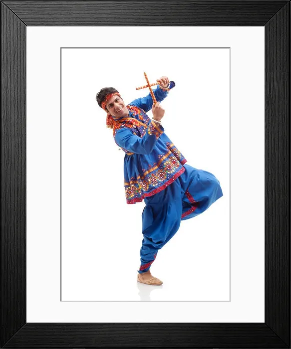 Framed Print : Portrait of happy young man in traditional wear performing Dandiya Rass over white background Framed Print : Portrait of happy young man in traditional wear performing Dandiya Rass over white background