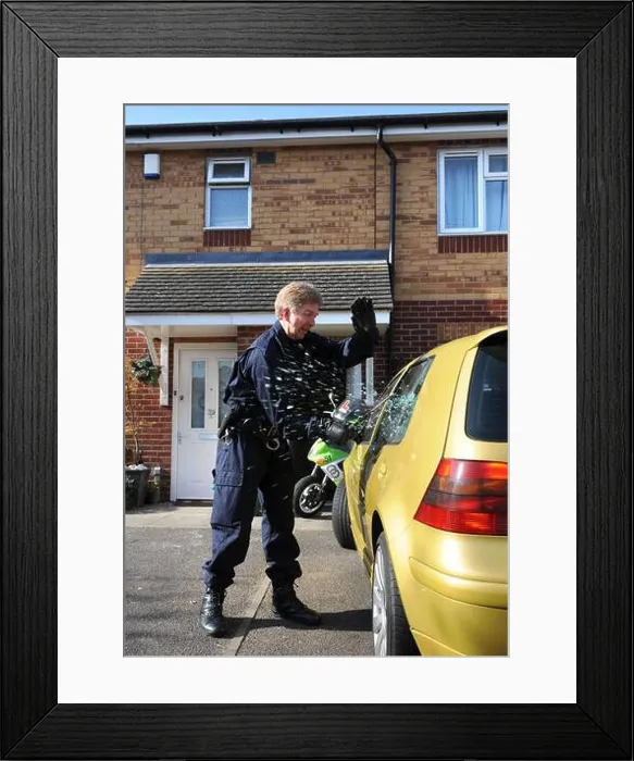 Framed Print : Police officers from the operational team break into a suspects car in Gloucester where one of a series of dawn raids Framed Print : Police officers from the operational team break into a suspects car in Gloucester where one of a series of dawn raids