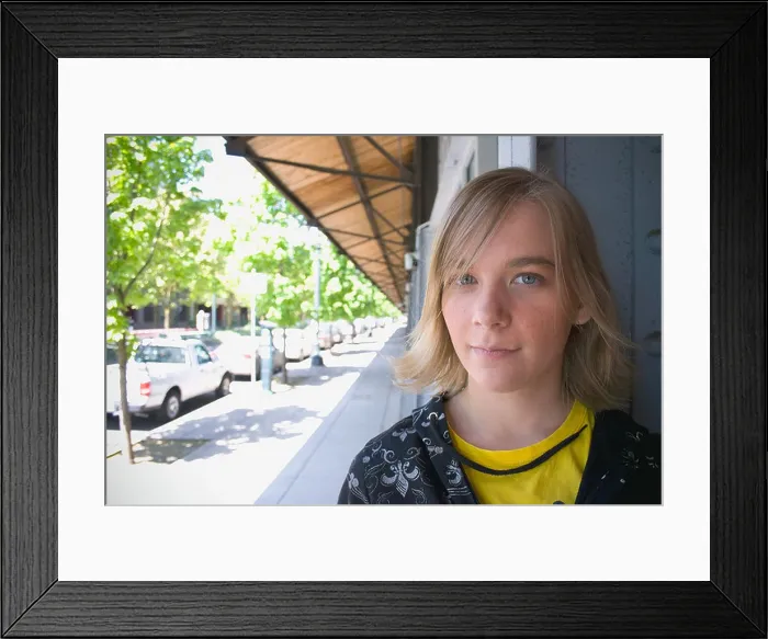 Framed Print : Teen sitting under a storefront awning looking at camera Framed Print : Teen sitting under a storefront awning looking at camera