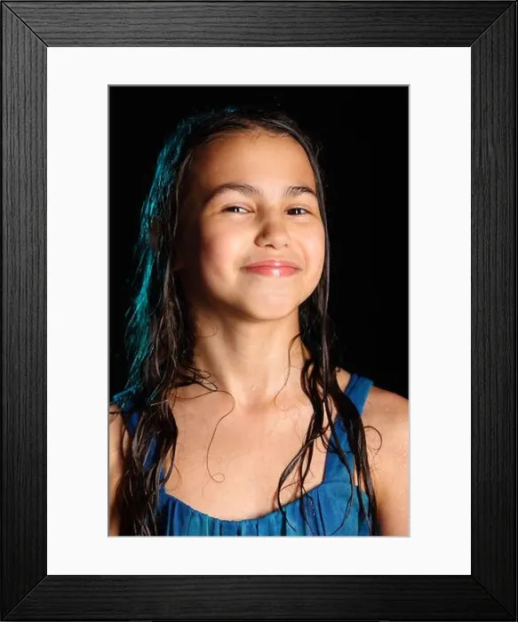 Framed Print : Close-up portrait of a bright cute cheerful brunette girl with wet hair on a black background Framed Print : Close-up portrait of a bright cute cheerful brunette girl with wet hair on a black background
