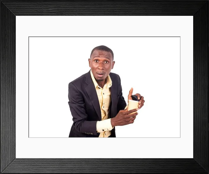 Framed Print : portrait of an astonished young businessman holding a paper coffee cup while looking at the camera Framed Print : portrait of an astonished young businessman holding a paper coffee cup while looking at the camera