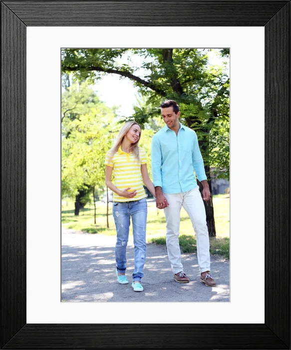 Framed Print : Young pregnant woman with husband walking in park Framed Print : Young pregnant woman with husband walking in park