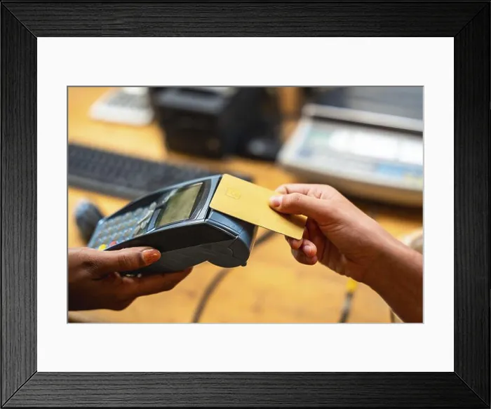 Framed Print : Customer making a purchase using a credit card on a point of sale terminal Framed Print : Customer making a purchase using a credit card on a point of sale terminal