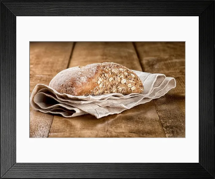 Framed Print : Rustic bread loaf with oats served on napkin on a wooden table Framed Print : Rustic bread loaf with oats served on napkin on a wooden table