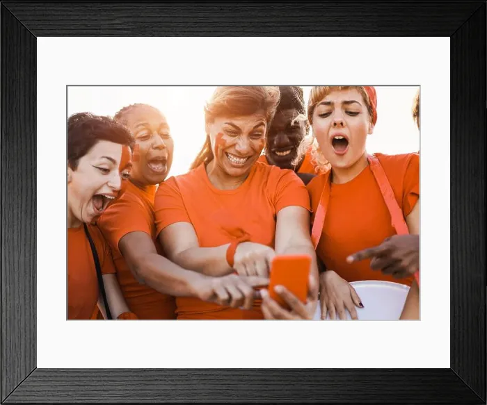 Framed Print : Orange sport supporters watching football game on mobile phone - Focus on center woman face Framed Print : Orange sport supporters watching football game on mobile phone - Focus on center woman face