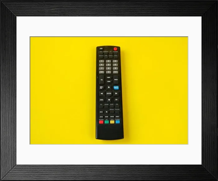 Framed Print : tv remote isolated on yellow background