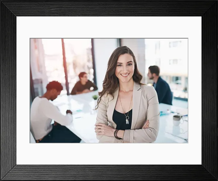Framed Print : She has a can do attitude. Portrait of a businesswoman in an office with her colleagues in the background Framed Print : She has a can do attitude. Portrait of a businesswoman in an office with her colleagues in the background