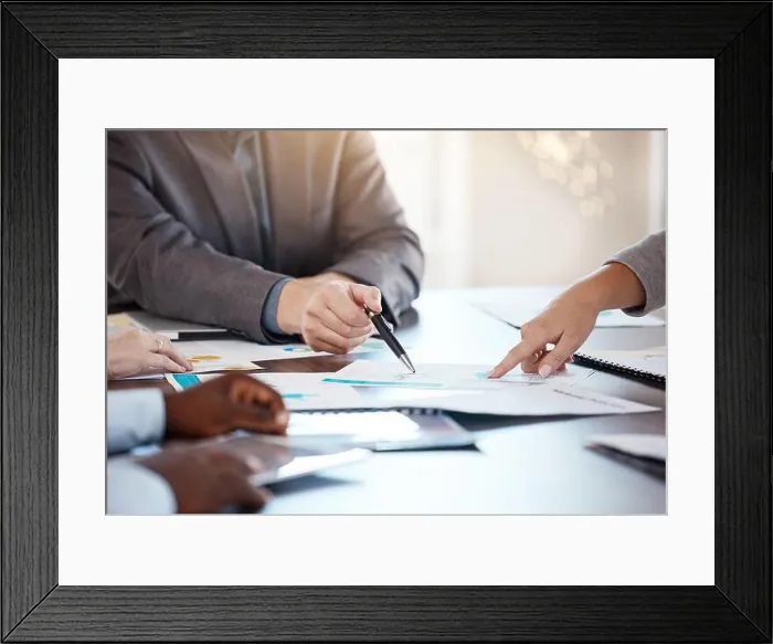 Framed Print : Corporate table, documents and hands in conversation on business analytics data report in office Framed Print : Corporate table, documents and hands in conversation on business analytics data report in office