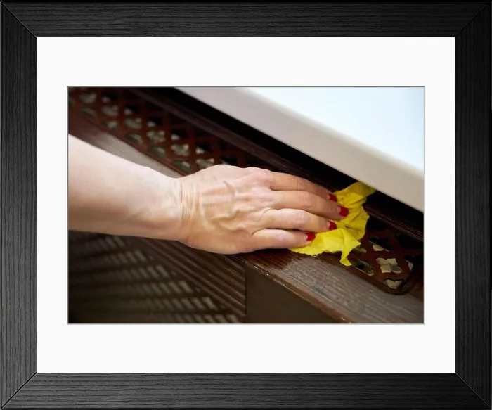 Framed Print : Woman wipes a window sill with a damp yellow rag Framed Print : Woman wipes a window sill with a damp yellow rag
