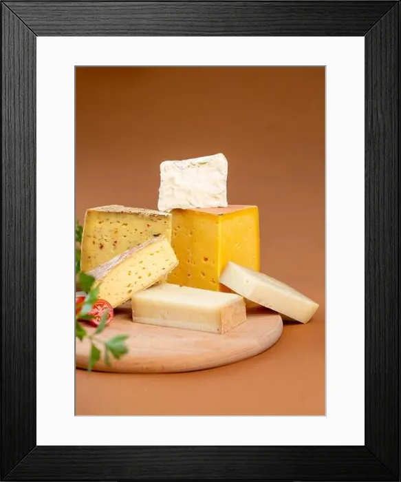 Framed Print : Pieces of assorted fresh cheese placed on wooden chopping board against brown background Framed Print : Pieces of assorted fresh cheese placed on wooden chopping board against brown background