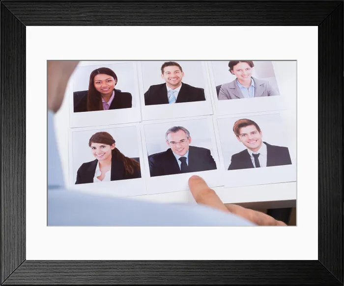 Framed Print : Close-up Of Businessperson Choosing Photograph Of Best Job Candidate Framed Print : Close-up Of Businessperson Choosing Photograph Of Best Job Candidate