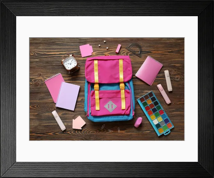Framed Print : Colorful school backpack with notebooks, watercolors and alarm clock on brown wooden background Framed Print : Colorful school backpack with notebooks, watercolors and alarm clock on brown wooden background