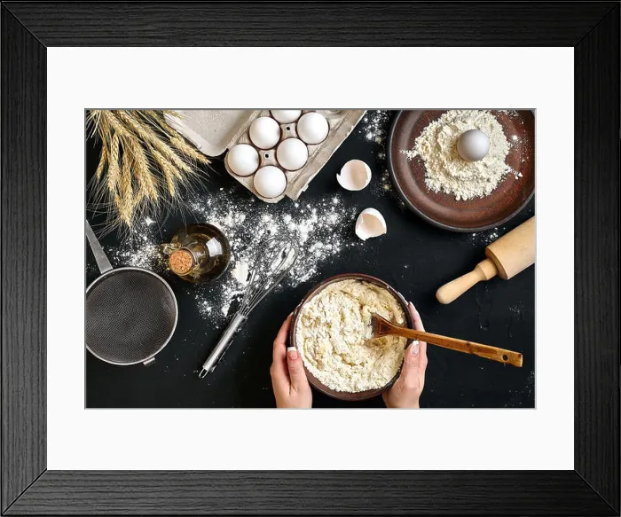 Framed Print : Female hands making / mixing dough in brown bowl on black table, baking preparation close-up Framed Print : Female hands making / mixing dough in brown bowl on black table, baking preparation close-up