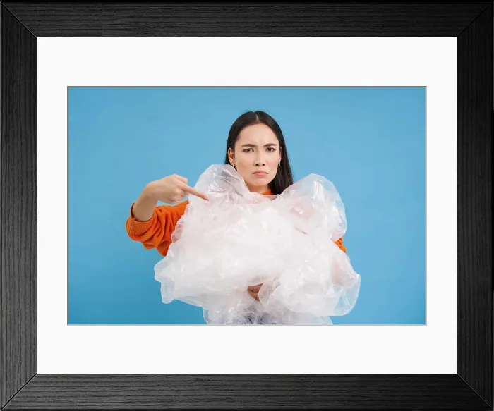 Framed Print : Angry eco-activist points at big pile of plastic bags Framed Print : Angry eco-activist points at big pile of plastic bags