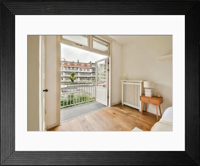 Framed Print : Bright and inviting bedroom featuring an open door that leads to a charming balcony Framed Print : Bright and inviting bedroom featuring an open door that leads to a charming balcony
