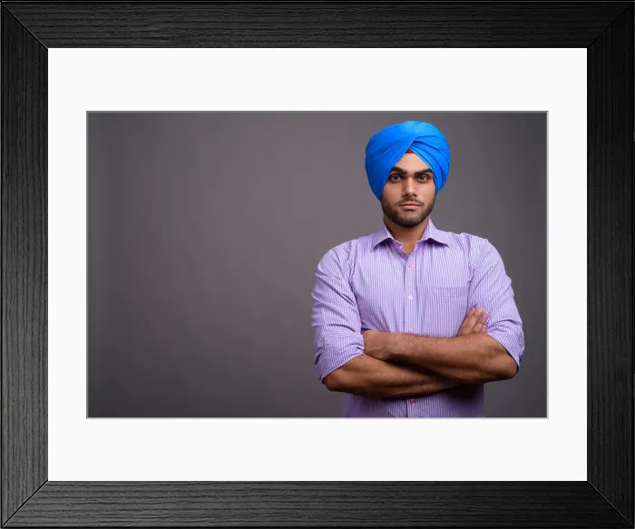 Framed Print : Young handsome Indian businessman wearing turban against gray ba Framed Print : Young handsome Indian businessman wearing turban against gray ba