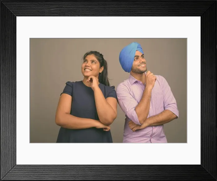 Framed Print : Young Indian couple together and in love against gray background Framed Print : Young Indian couple together and in love against gray background