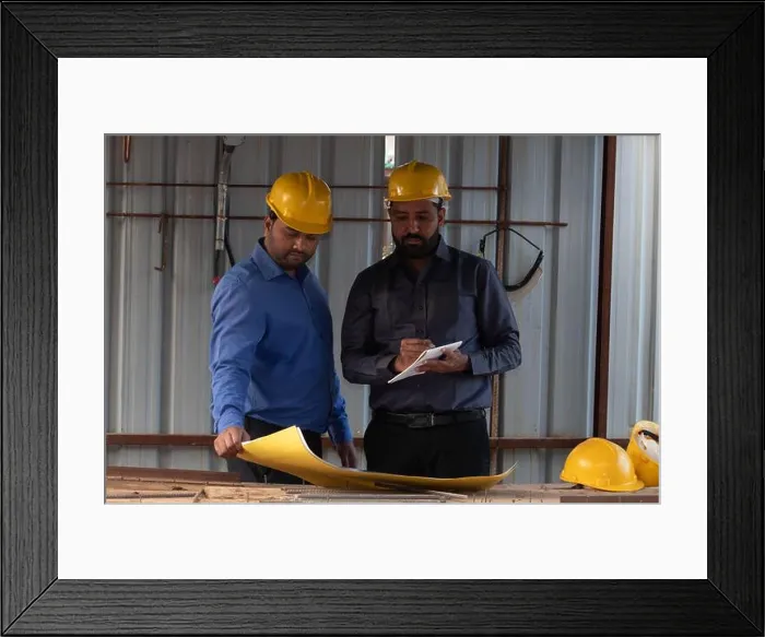 Framed Print : Civil engineer holding a blueprint while colleague is taking notes into notepad Framed Print : Civil engineer holding a blueprint while colleague is taking notes into notepad