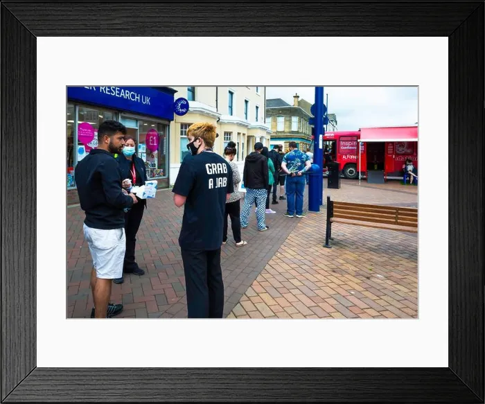 Framed Print : A queue of people awaiting Covid 19 vaccinations at a temporary facility in a red bus at Redcar cleveland helpers Framed Print : A queue of people awaiting Covid 19 vaccinations at a temporary facility in a red bus at Redcar cleveland helpers
