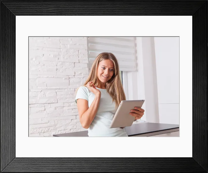 Framed Print : Blonde girl using tablet, surprised expression on her face, watching some video or picture on the screen Framed Print : Blonde girl using tablet, surprised expression on her face, watching some video or picture on the screen