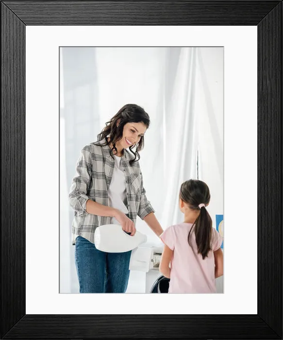 Framed Print : mother in grey shirt pouring liquid laundry detergent in washer wile daughter in pink t-shirt standing near in laundry Framed Print : mother in grey shirt pouring liquid laundry detergent in washer wile daughter in pink t-shirt standing near in laundry