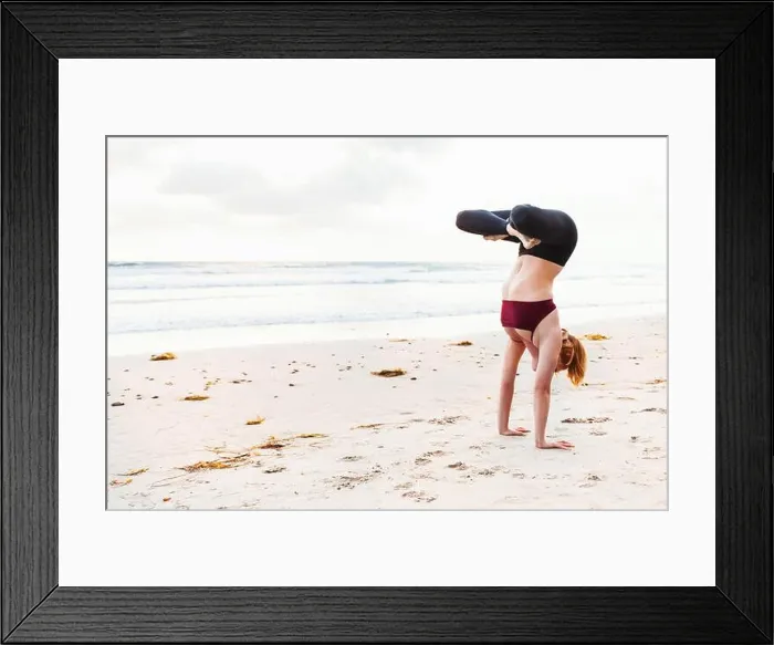 Framed Print : Mid adult woman upside down in yoga position on beach