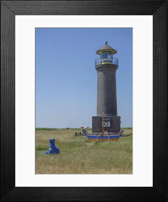 Framed Print : Brick lighthouse next to boat and blue sculpture in a meadow under blue sky, juist, north sea, germany Framed Print : Brick lighthouse next to boat and blue sculpture in a meadow under blue sky, juist, north sea, germany