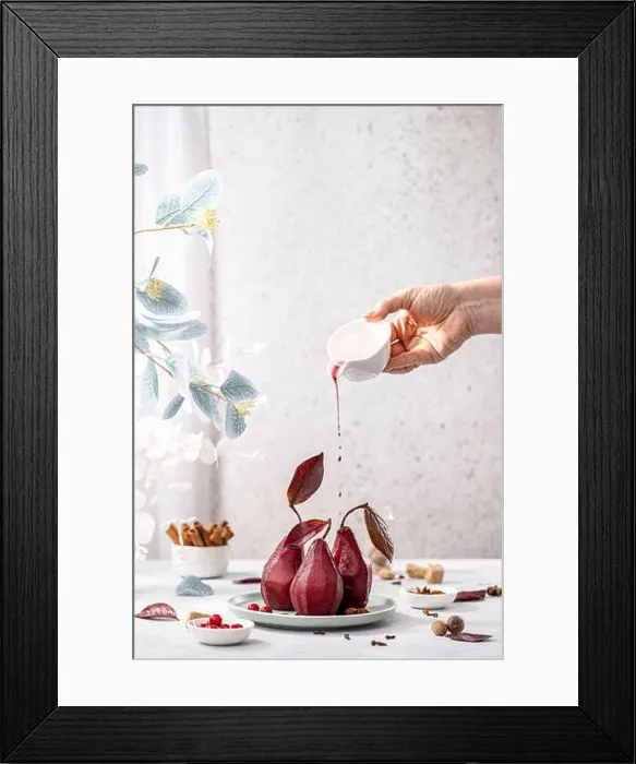 Framed Print : Women hand is pouring wine from small jar to plate with Traditional french dessert pears stewed in red wine