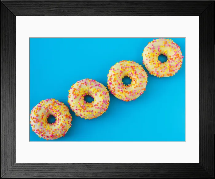 Framed Print : A group of bright motley donuts with sprinkles on blue background in abstract style Framed Print : A group of bright motley donuts with sprinkles on blue background in abstract style