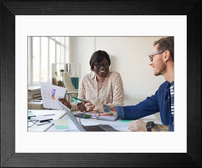 Framed Print : Portrait of two IT developers smiling while designing interface for mobile application or website, copy space