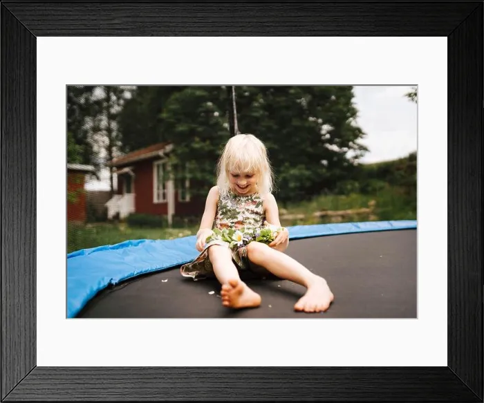 Framed Print : Smiling girl sitting on trampoline Framed Print : Smiling girl sitting on trampoline