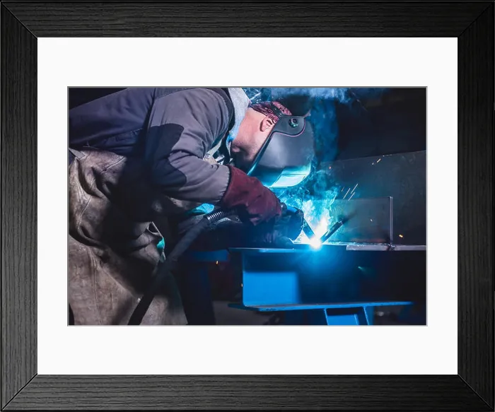 Framed Print : Industrial Welder With Torch and Protective Helmet in big hall welding metal profiles Framed Print : Industrial Welder With Torch and Protective Helmet in big hall welding metal profiles