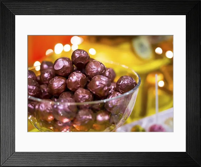Framed Print : Chocolate bonbons wrapped in purple foil in a glass bowl Framed Print : Chocolate bonbons wrapped in purple foil in a glass bowl