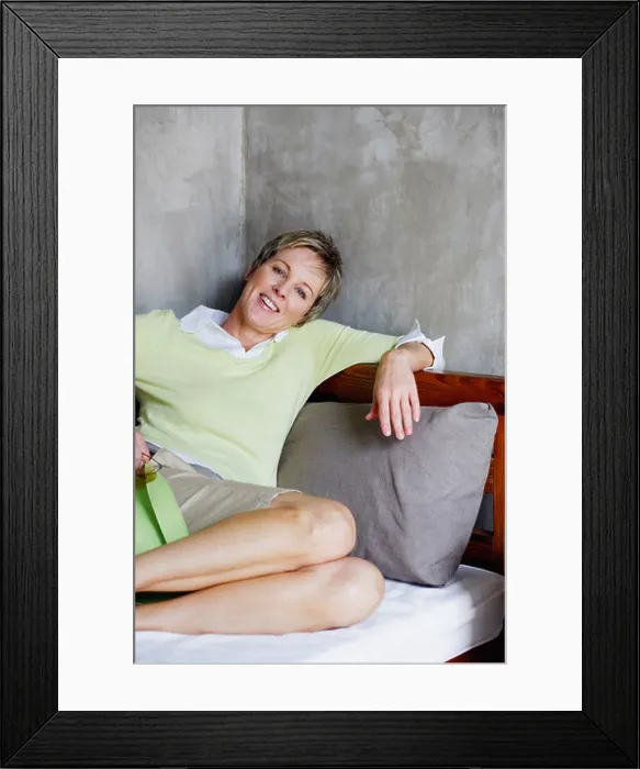 Framed Print : Portrait of a mature woman reclining on the bed and smiling Framed Print : Portrait of a mature woman reclining on the bed and smiling