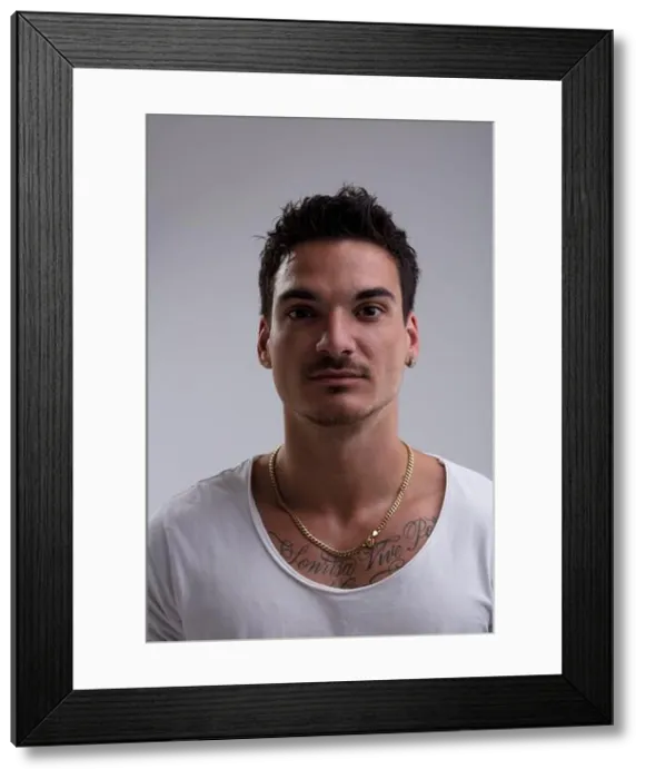 Framed Print : Headshot of a serious young man with tattoos and a gold chain posing in a studio setting Framed Print : Headshot of a serious young man with tattoos and a gold chain posing in a studio setting