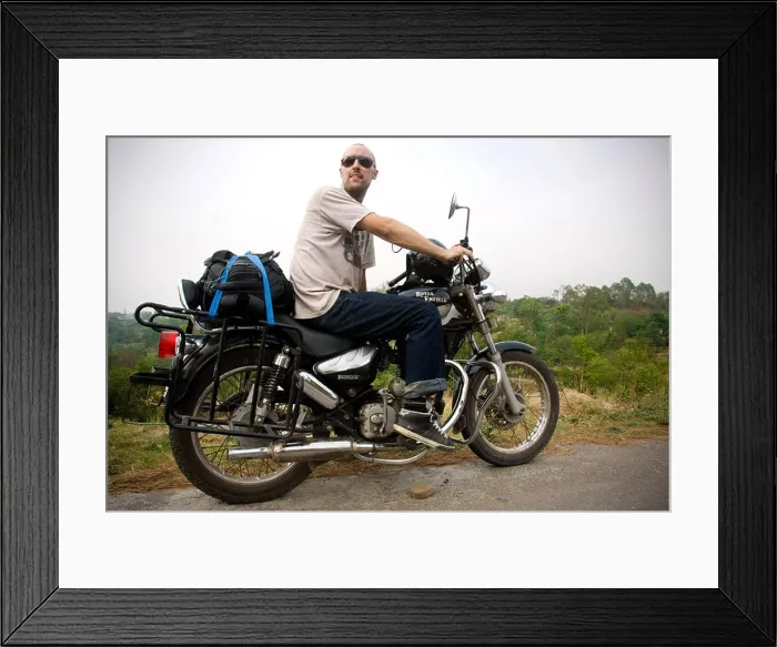 Framed Print : A man sits on a Royal Enfield 'bullet' motorbike during a motorcycle tour in the Himalayas in Himachal Pradesh in India
