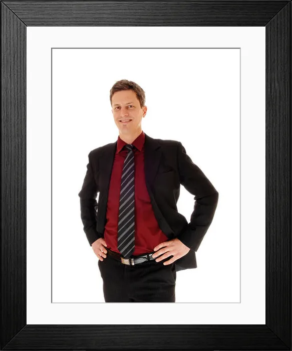 Framed Print : An business man in a suit standing isolated for white background with his hands on his hips and smiling Framed Print : An business man in a suit standing isolated for white background with his hands on his hips and smiling