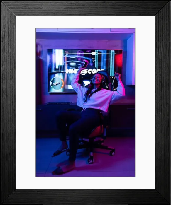 Framed Print : A biracial young female wearing white hoodie, playing video games at home Framed Print : A biracial young female wearing white hoodie, playing video games at home