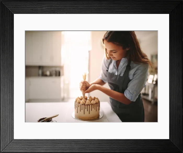 Framed Print : Woman decorating chocolate cake in the kitchen. Female chef making a cake at home Framed Print : Woman decorating chocolate cake in the kitchen. Female chef making a cake at home