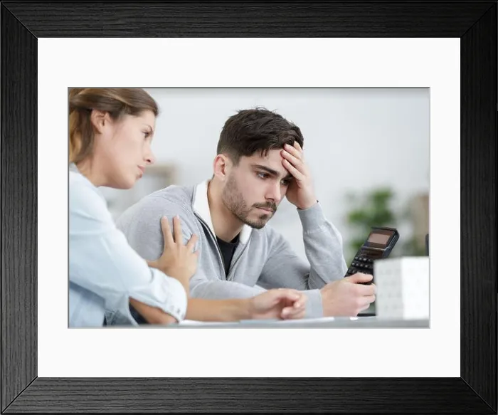 Framed Print : couple looking depressed as they do some calculations