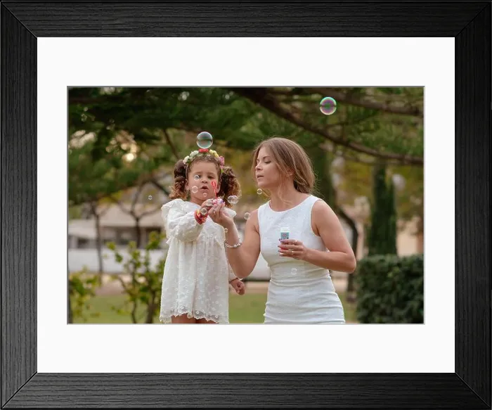 Framed Print : Mother and daughter blow soap bubbles outdoors Framed Print : Mother and daughter blow soap bubbles outdoors
