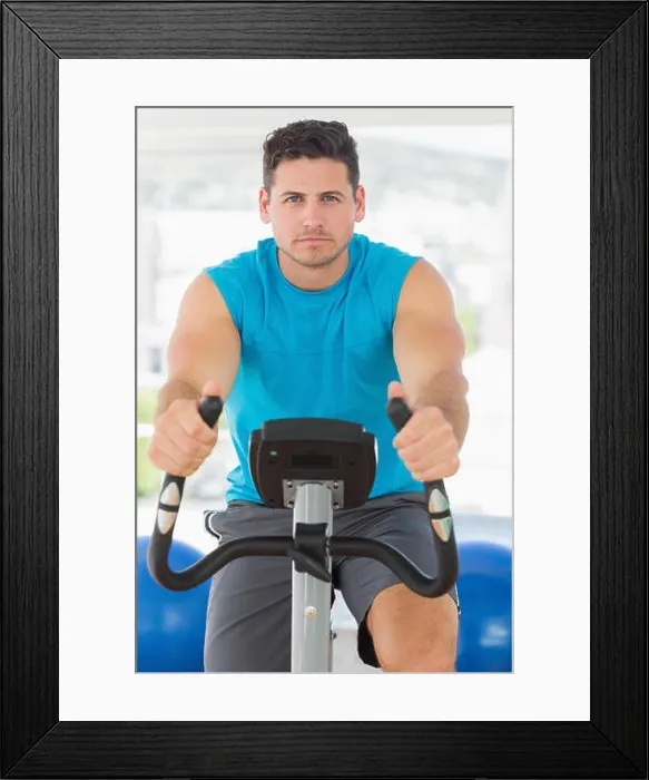 Framed Print : Serious young man working out at spinning class Framed Print : Serious young man working out at spinning class