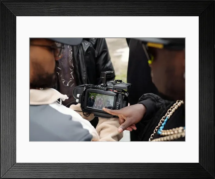 Framed Print : Group of individuals gathered around camera while reviewing shot taken during outdoor location shoot Framed Print : Group of individuals gathered around camera while reviewing shot taken during outdoor location shoot
