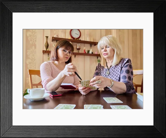 Framed Print : Two middle aged women laying out cards at home on the table Framed Print : Two middle aged women laying out cards at home on the table