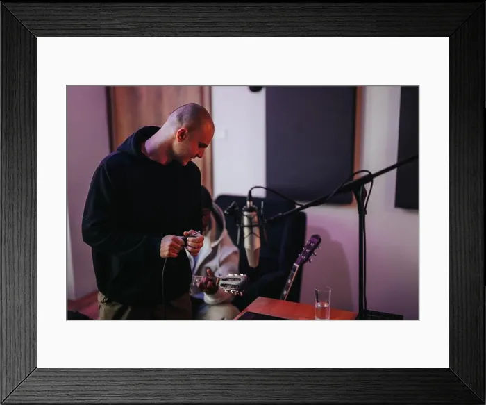 Framed Print : The image captures a musician and a producer working together in a modern recording studio Framed Print : The image captures a musician and a producer working together in a modern recording studio