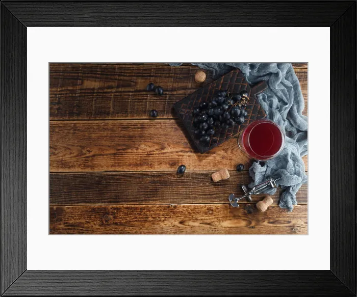 Framed Print : Red wine in a glass goblet with grapes and a vintage corkscrew on a wooden background. Top view with space for text Framed Print : Red wine in a glass goblet with grapes and a vintage corkscrew on a wooden background. Top view with space for text