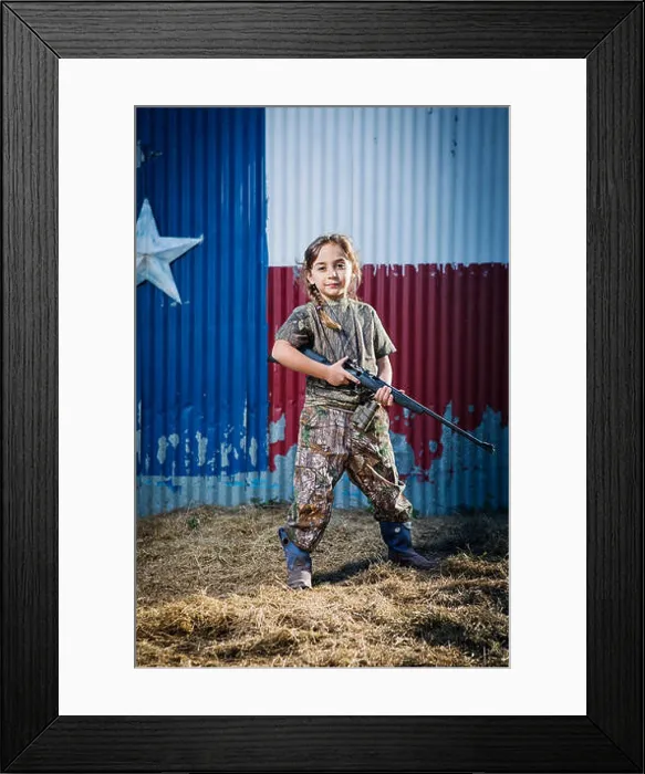 Framed Print : Portrait of confident girl holding rifle while standing on field Framed Print : Portrait of confident girl holding rifle while standing on field