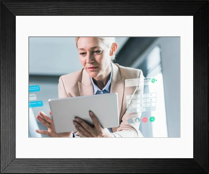 Framed Print : Businesswoman sitting in office, using digital tablet Framed Print : Businesswoman sitting in office, using digital tablet