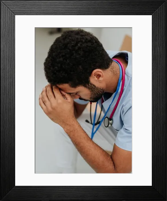Framed Print : High angle view of tired doctor, sitting at hospital corridor Framed Print : High angle view of tired doctor, sitting at hospital corridor